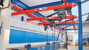 DC chain hoists on Demag KBK trolleys on an orange Demag enclosed rail crane system