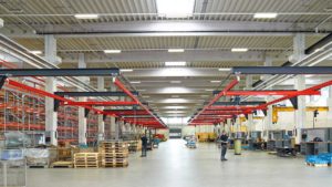 Demag KBK Modular Cranes and DC Chain Hoists lifting loads in a production facility.